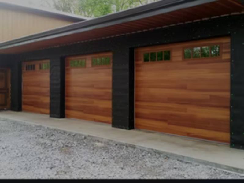 Three cedar-look insulated sectional garage doors with window rows on a dark-trimmed triple garage